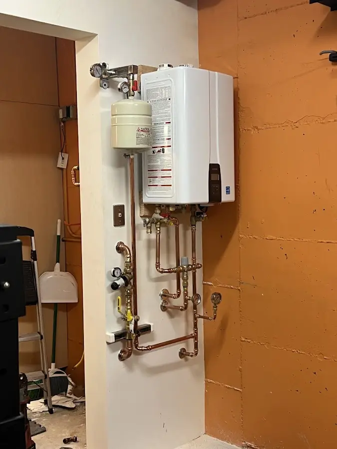 Plumbing technician inspecting water heater connections in Charlotte